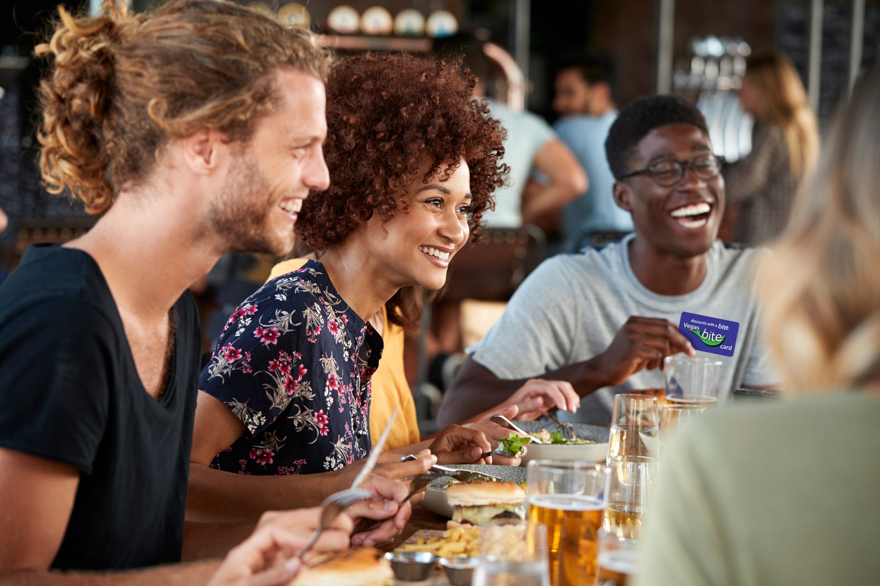 group of people enjoying dining out and using card for discounts